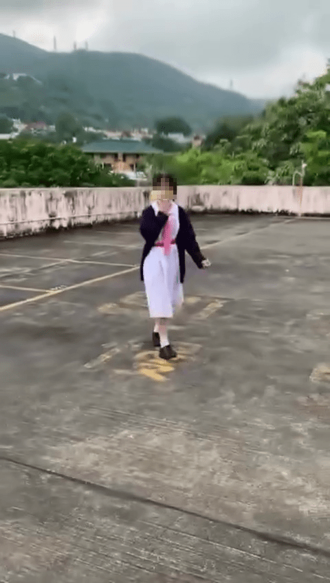 一名身穿校服的中學女生在一處天台「邊行邊食煙」，相信是其友人將她吸煙和吐出煙圈的行為拍攝下來。網圖