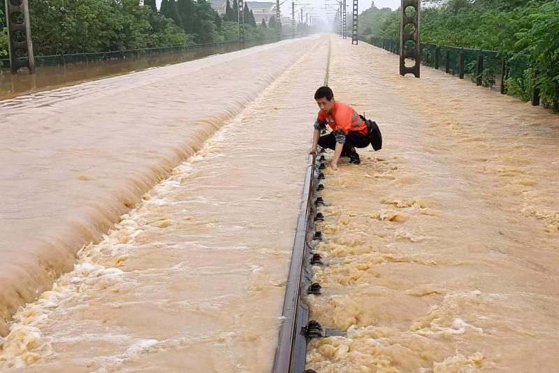 2022年6月江西上饶市水灾，工人检查被淹浸的铁道路轨。 资料图片