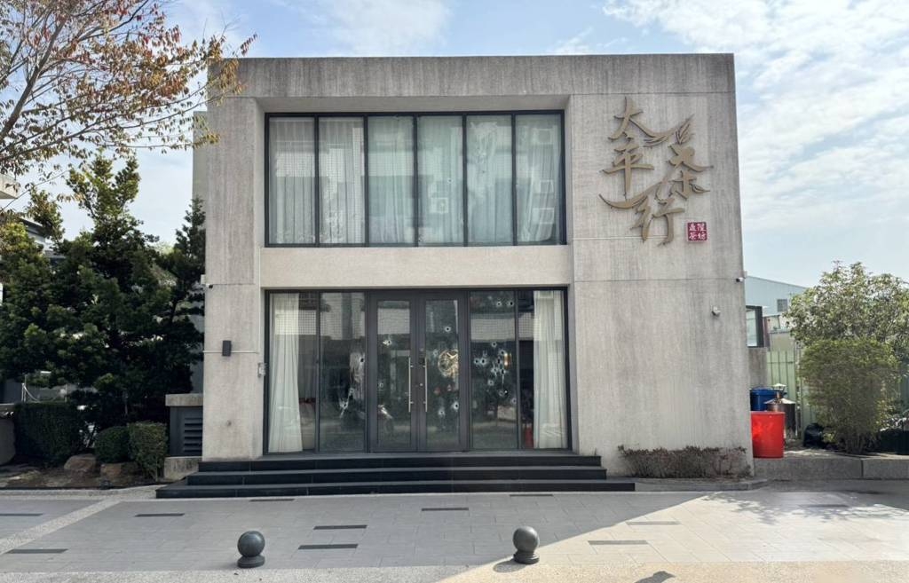 茶行玻璃門遭掃成蜂窩，槍手隨後帶槍投案。 中時