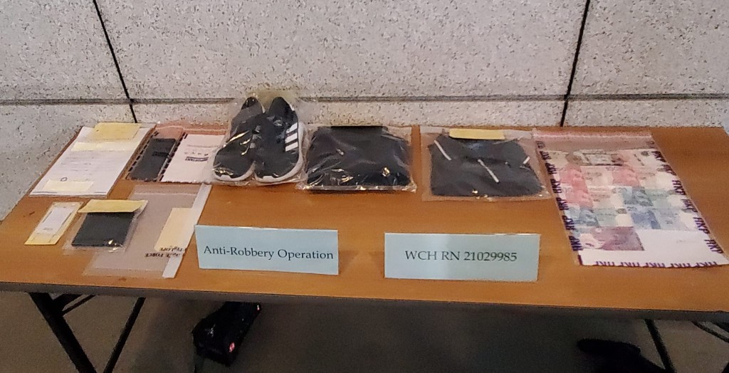 警方於疑犯身上檢獲逾千元現金,及在其劏房單位內檢獲犯案時所穿衣物。