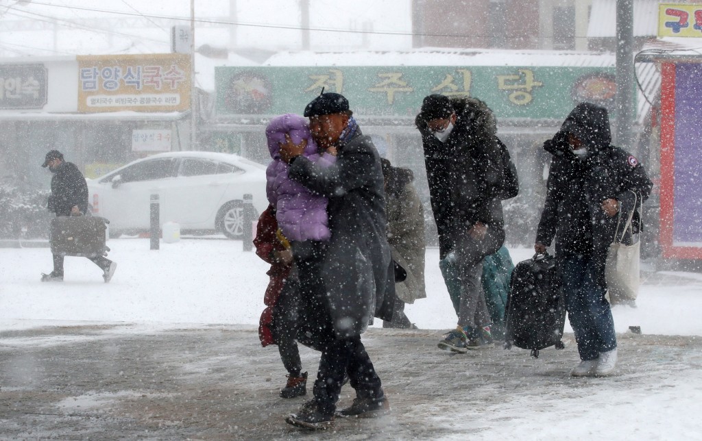 乘客冒著大雪前往光州的火车站。路透社