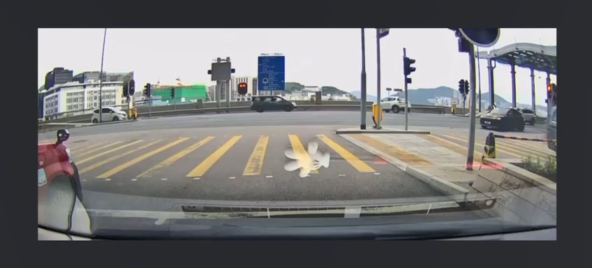 白色私家車駛至路口時突然違規掉頭。 白色私家車駛至路口時突然違規掉頭。