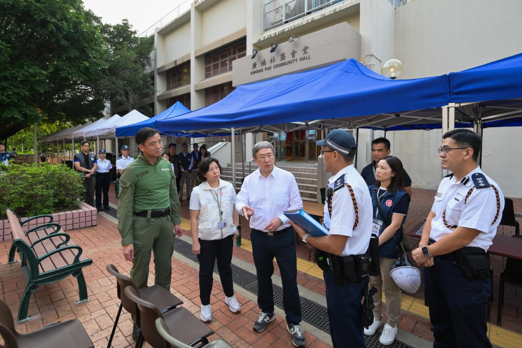 卓永兴（左三）在广福社区会堂实地了解扩大装备穿戴区并增加桌椅数目及加设帐篷挡雨的操作。旁为社会福利署副署长（服务）梁绮莉（左二）和香港警务处行动处处长吕锦豪（左一）。