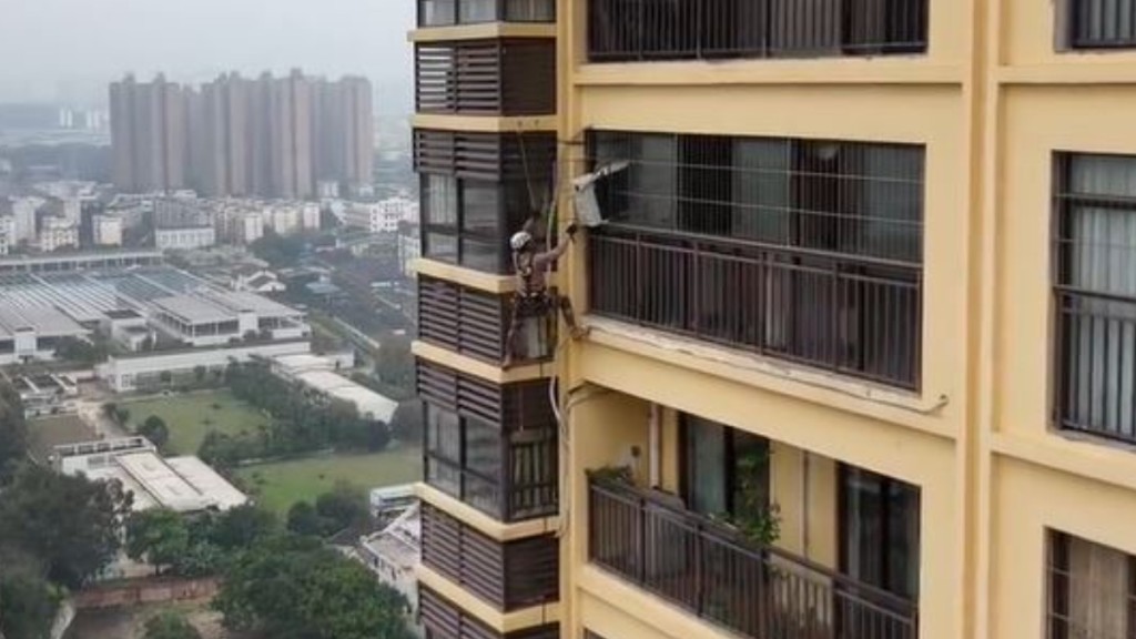 內地許多樓宇的設計被批不合理,要工人在高空冒險安裝維修冷氣機。