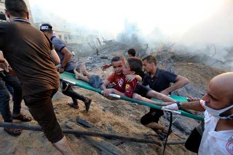 加沙城遭以軍空襲後，巴人從廢墟中救走兩名受傷男孩。美聯社