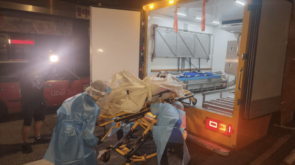 周四凌晨2時許,仵工將死者遺體從單位移走。黎志偉攝 周四凌晨2時許,仵工將死者遺體從單位移走。黎志偉攝