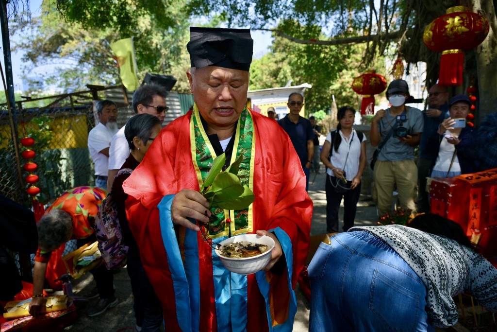 喃嘸師傅在神壇前誦經祈福，並逐一念出各家各戶姓名，以祈求平安順遂。