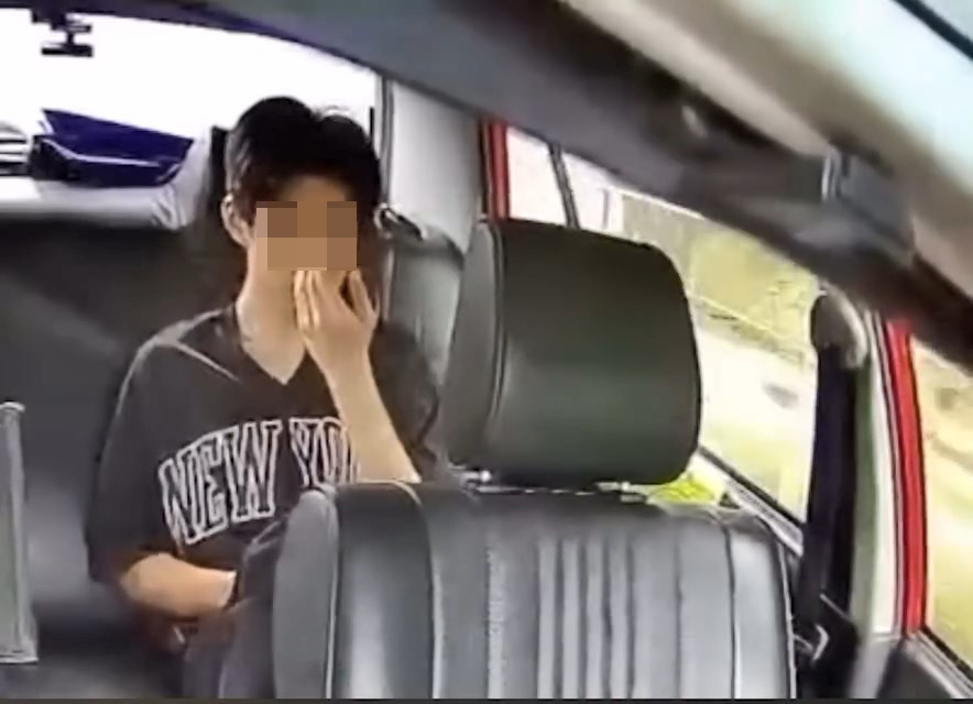 一名青年坐在的士左邊後座,不時四處張望。 一名青年坐在的士左邊後座,不時四處張望。