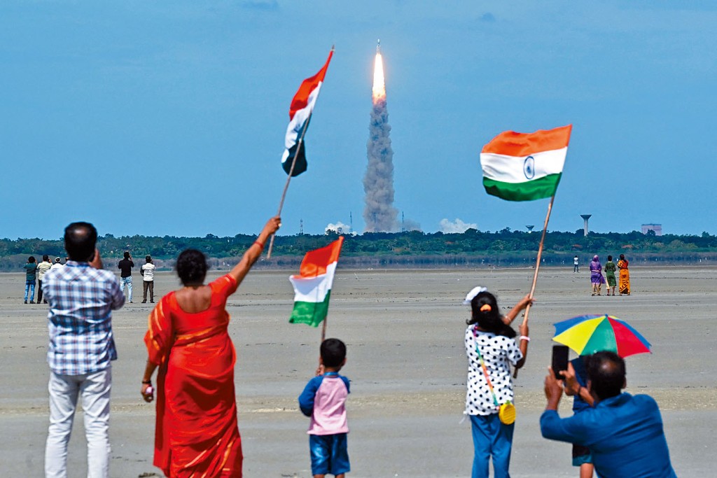 載有印度「月船3號」探測器的火箭，從安德拉邦小島發射升空，民眾揮舞國旗歡呼。　