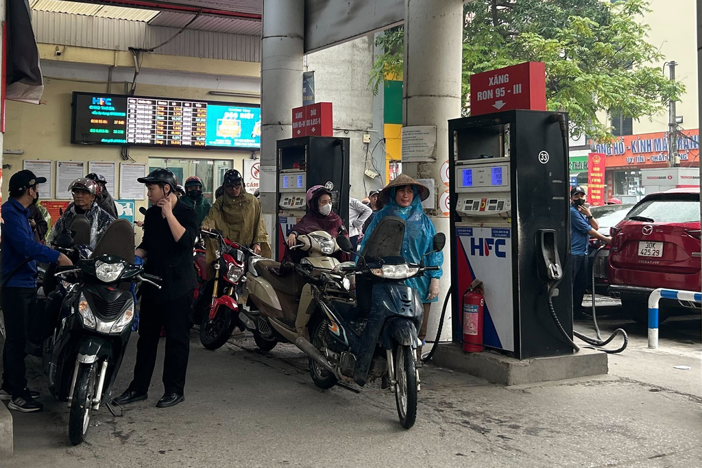 電單車騎士在越南河內的加油站排隊加油。（美聯社）