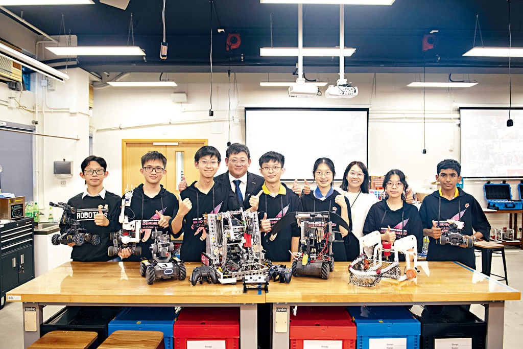 機械人隊學生聯同吳冠明首席助理校長展現參與設計的機械 作品，曾出戰國際比賽，充滿實力。
