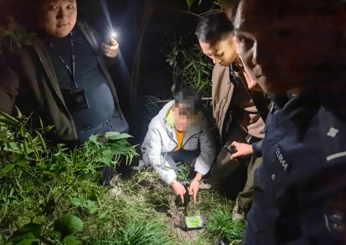 李某帶警察前往藏錢地點。環球網 李某帶警察前往藏錢地點。環球網