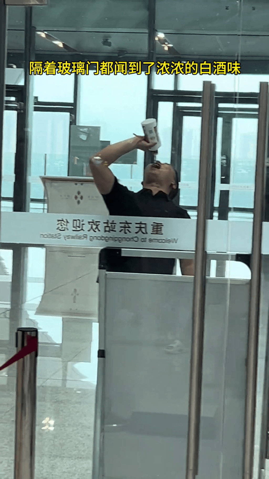男乘客在安檢旁一口接一口的將整瓶茅台喝了。