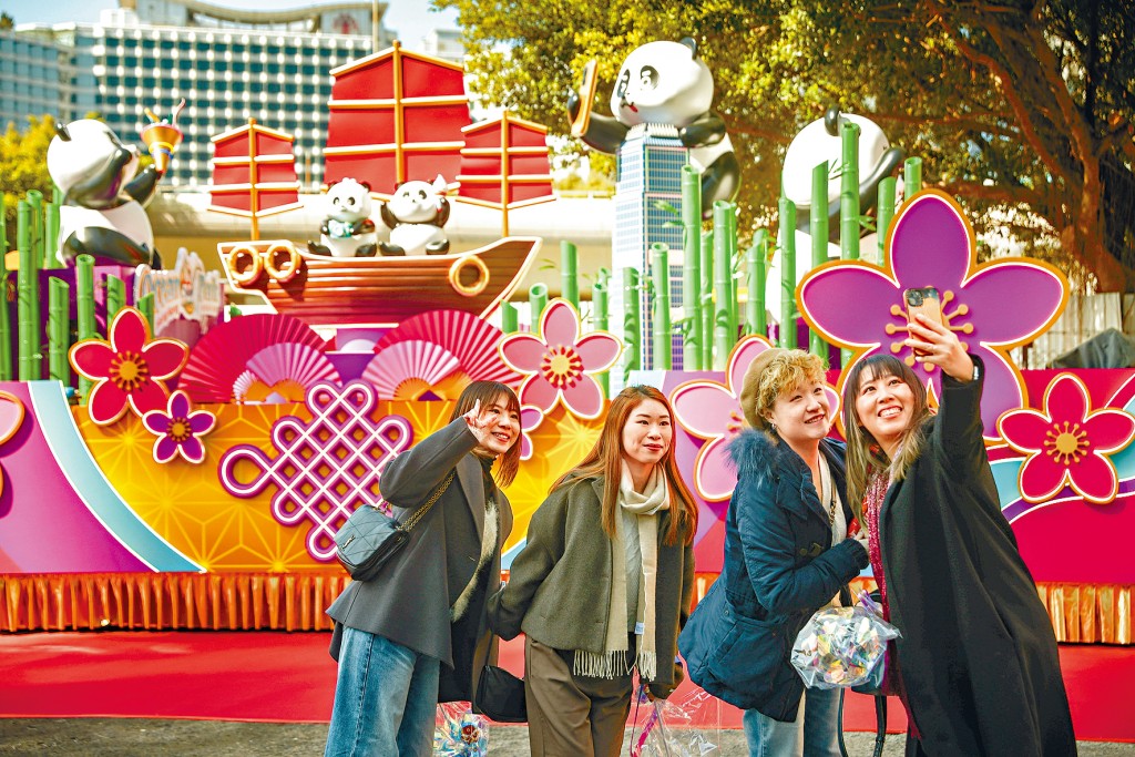 遊人在有熊貓一家六口的花車前率先「打卡」，體驗新春歡樂氣氛。