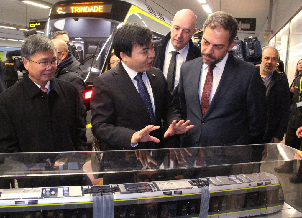 中車唐山公司總經理譚沐（中）在列車模型前向葡萄牙環境與氣候行動部部長科代羅（前排右）和中國駐葡萄牙大使趙本堂（前排左）講解。 新華社