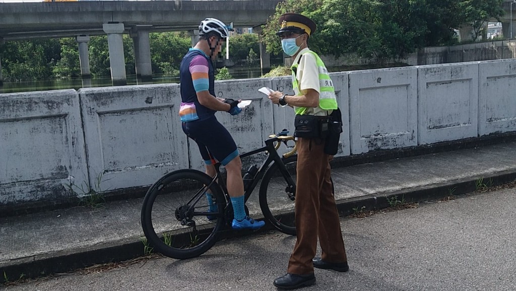 執法人員向騎踏單車人士派發宣傳單張。圖:警方提供