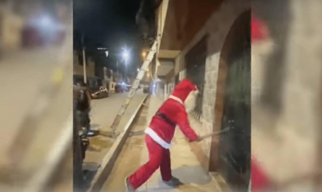 秘鲁电视新闻片段，一个突上红衣红裤圣诞老人打扮的彪型大汉，在飘着雪的街头，猛力用手中大铁锤砸向一家房子的门户，他不是劫匪，而是警察。