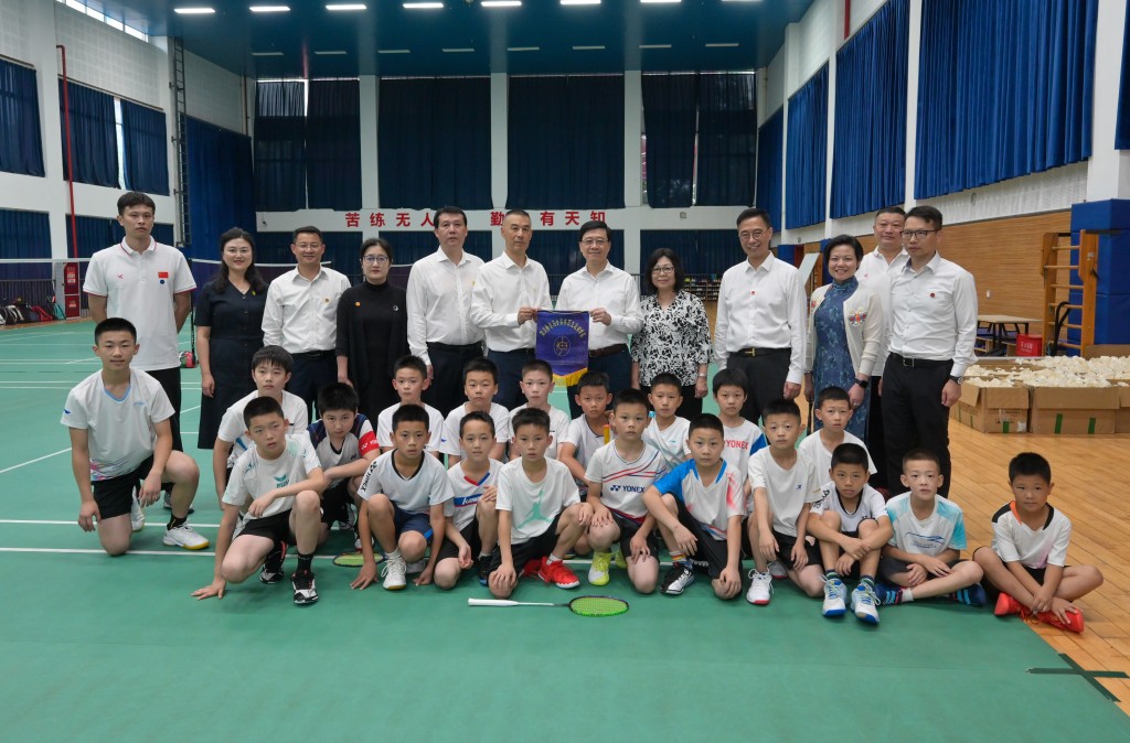 後排左七起：李家超及夫人、文化體育及旅遊局局長楊潤雄，以及其他官員在四川香港馬會奧林匹克運動學校與練習羽毛球的學生合照。