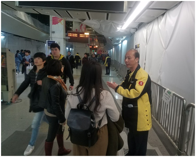 港鐵職員在紅磡站 向乘客講解 有關 轉乘接駁巴的安排。歐陽偉光攝