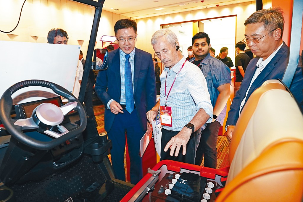 科學園初創Hessner聯合始創人Clayton Gray（中）向創新科技及工業局局長孫東教授（左）介紹超級電容模組，可以改善低速電動車續航及電池壽命。