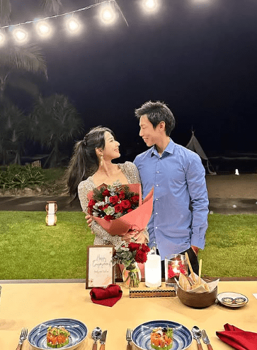 蔡頌思在草坪上與男友深情對望，身前的桌子擺放了寫有「Happy engagement」的卡紙及美味佳餚，不難看出二人求婚成功的喜悅甜蜜。