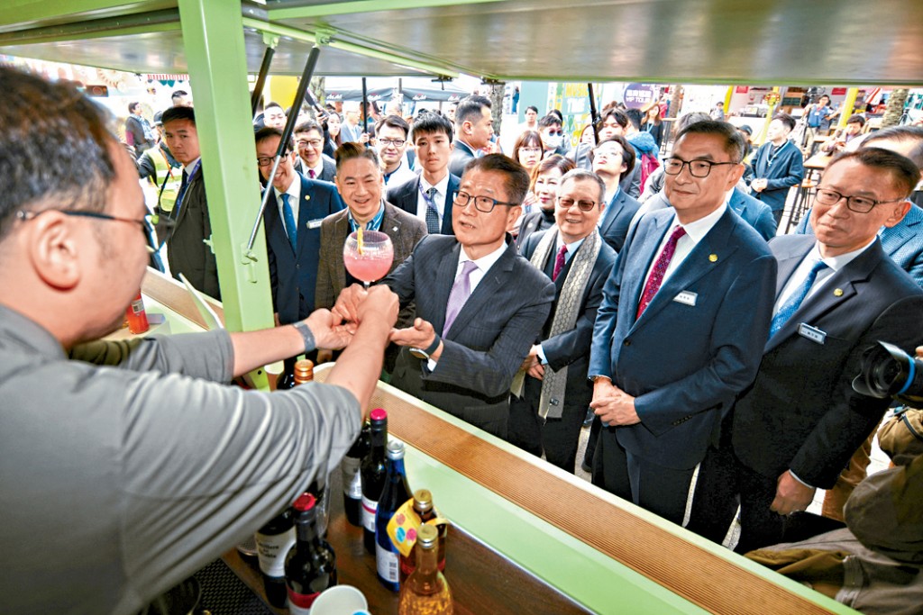 陳茂波到一個攤位品嘗雞尾酒,其後更舉起拇指讚好。