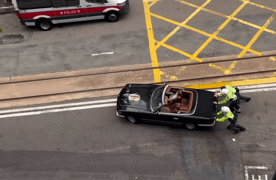 3名警員合走將車推回路邊。網上圖片 3名警員合走將車推回路邊。網上圖片