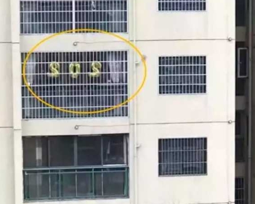 鄰居見對面樓一單位窗口貼了SOS,以為是求救報警,結果是一場誤會。(網圖)