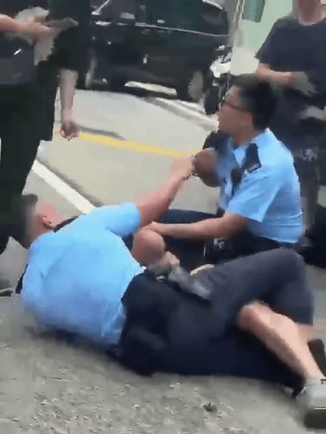 兩名警員制服其中一名男子。