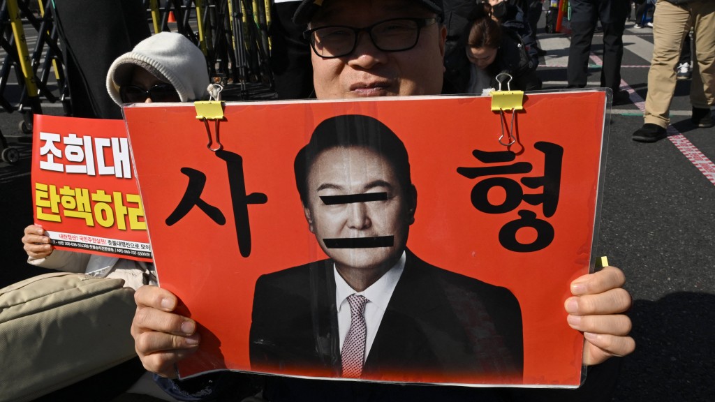 反對者手持南韓前總統尹錫悅照片，上面並寫著「死刑」。法新社