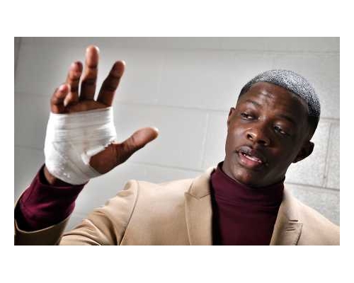 夺去枪手步枪的顾客展示手部伤势。AP