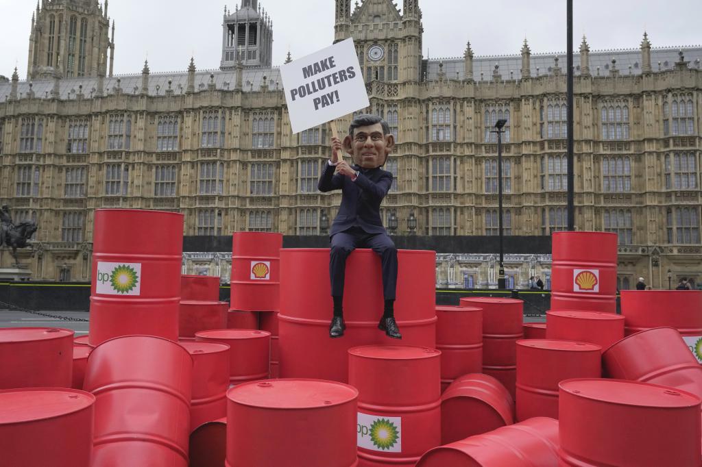 在联合国「气候雄心」峰会前夕，乐施会成员戴起辛伟诚面具，周二在伦敦国会外示威，呼吁英国的石油公司增缴税款。美联社