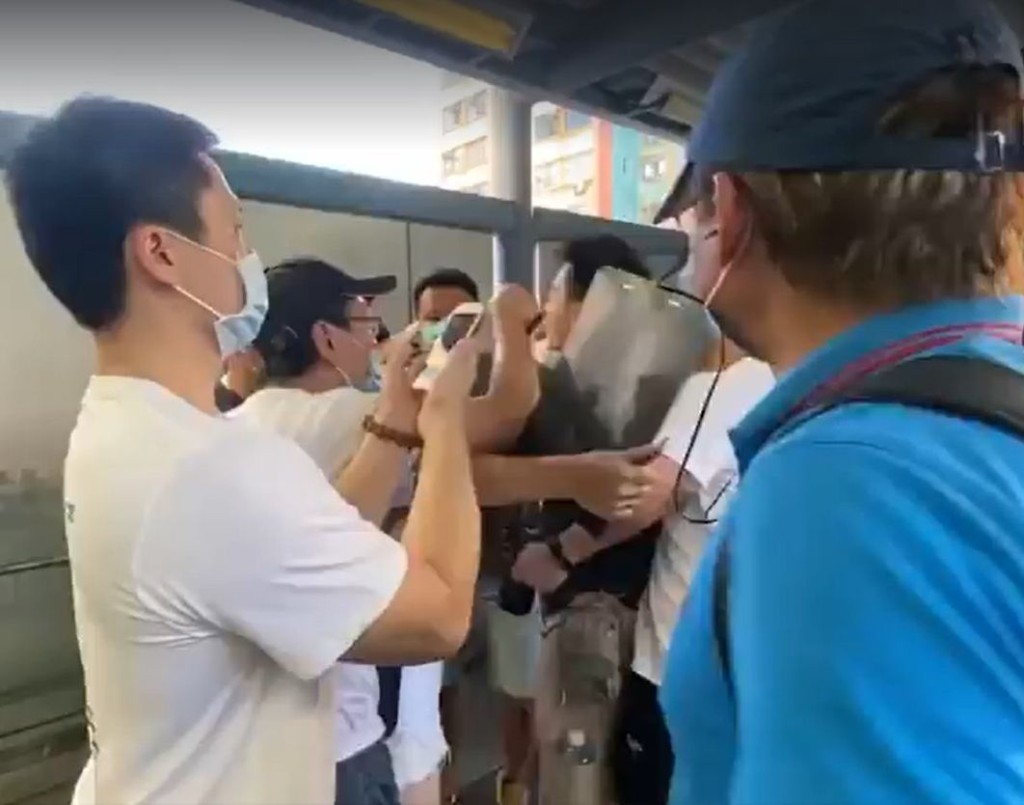 有攝影師遭白衣人包圍。黃子悅FB影片截圖