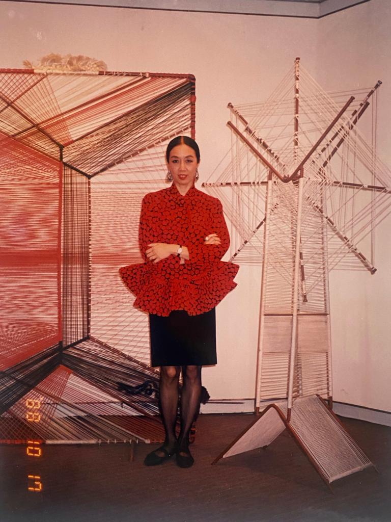 宋懷桂以一身皮爾 •卡丹時裝出席展覽開幕禮，她身後是女兒宋小虹的壁掛作品 |1988年 |彩色照片