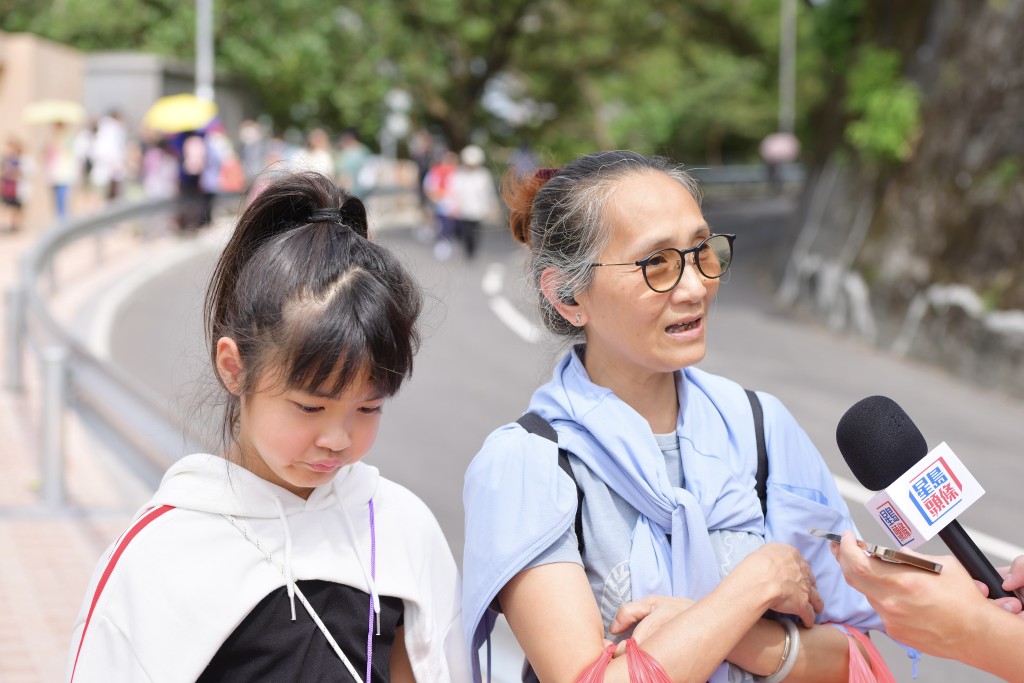 李女士與孫女兩人來拜山，她指往年乘搭地鐵到柴灣站後，要步行約20分鐘上山，形容有電梯後「快好多，冇咁喘氣」。歐樂年攝