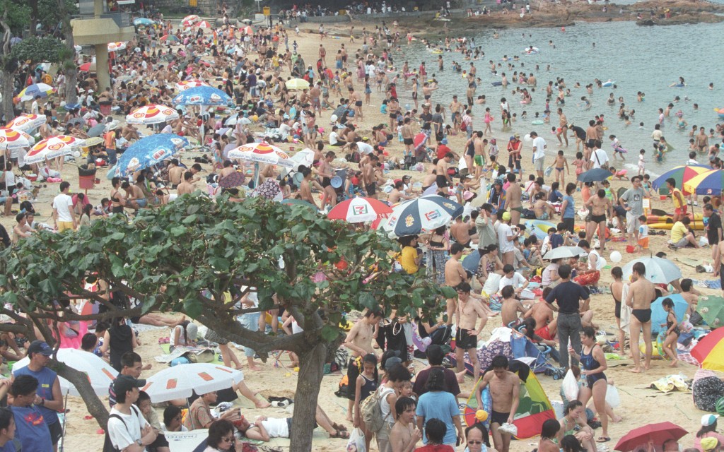 跟着龙舟游泳成为了节日习俗，每逢端午沙滩都人山人海。资料图片