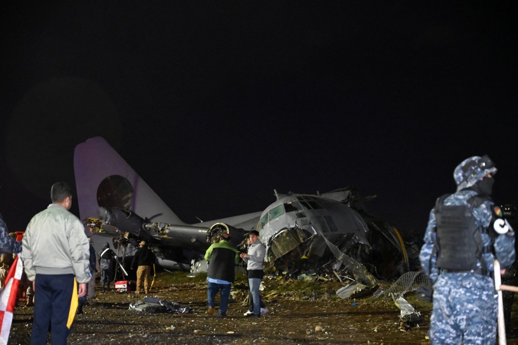 有民众想检拾钞票，军警在场看管。路透社