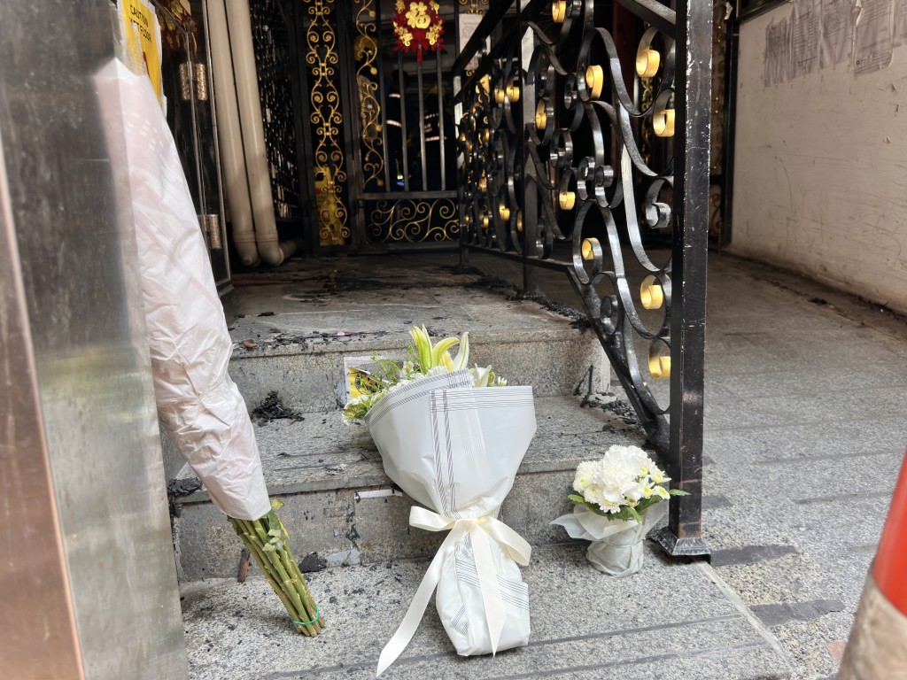 街坊在地下摆放鲜花悼念死难者。梁国峰摄