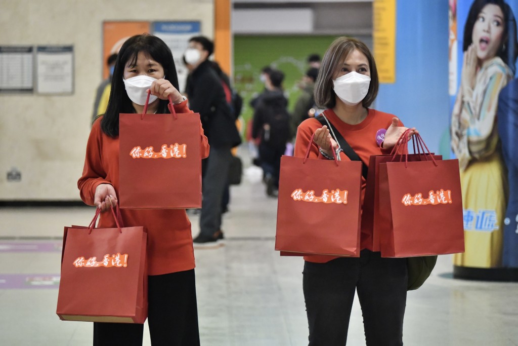 工作人員向旅客派發寫有「你好，香港！」字句的福袋。（陳極彰攝）