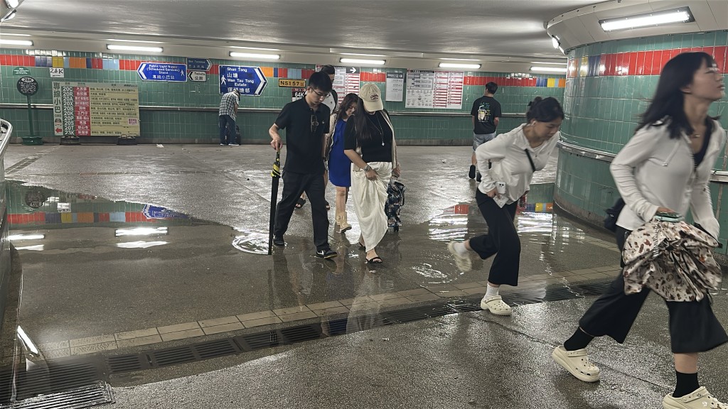 大埔墟站行人隧道有積水，市民要涉水而行。劉漢權攝