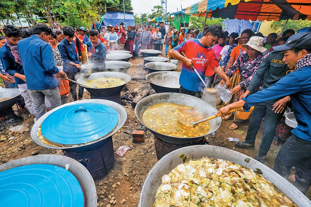 在柬埔寨邊境地區,逃離炮火的民眾等待領取食物。