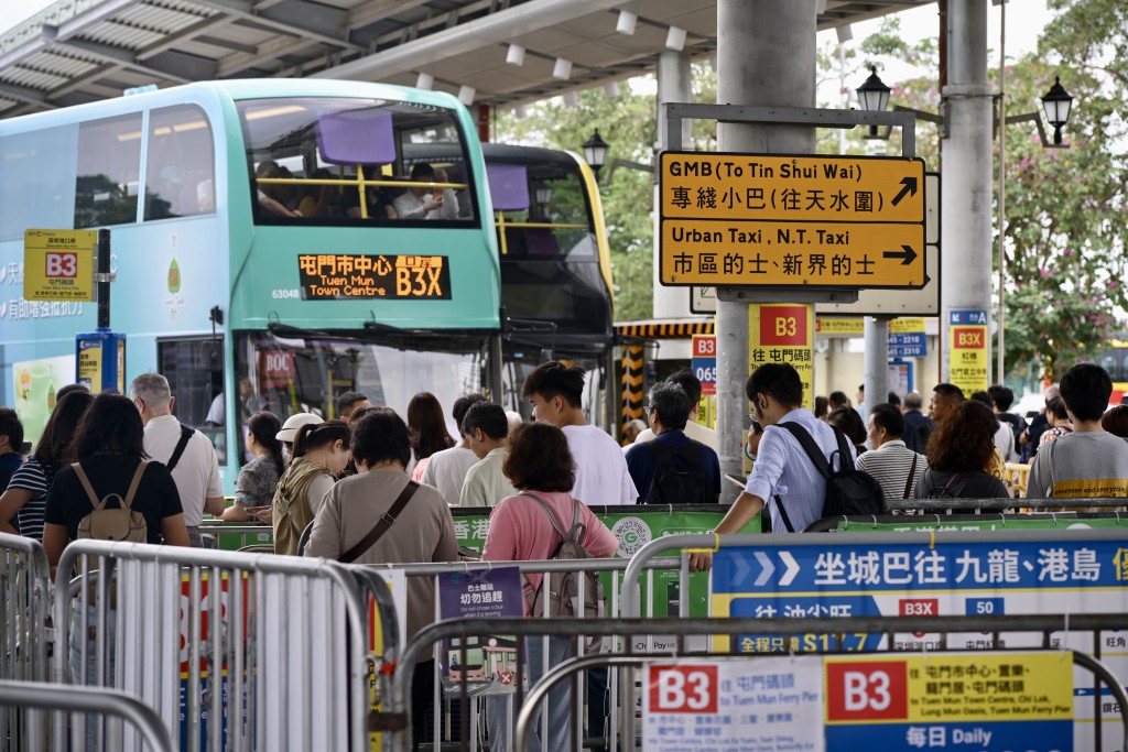 市民有序從通道排隊，按指示前往乘坐巴士或旅遊巴。