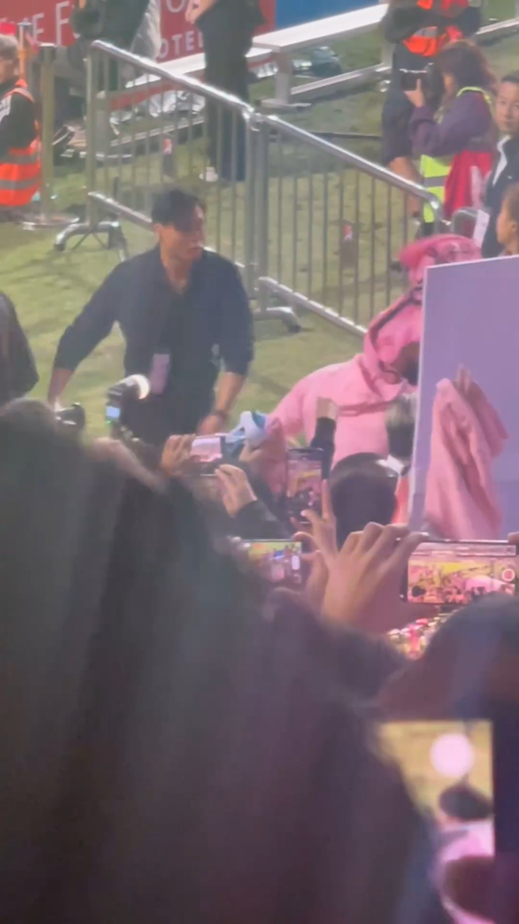 突然有球迷从被观众席的人群中，将一件粉红的球衣扔中了美斯。