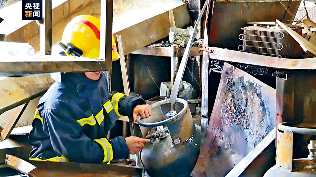 消防員進入事發現場檢查石油氣罐。