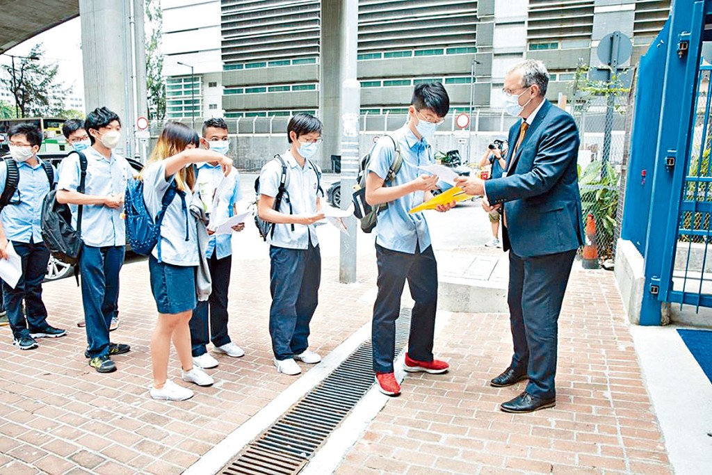 宣道國際學校學生昨抵校時要交健康申報表,校長溫德培在門口迎接學生。