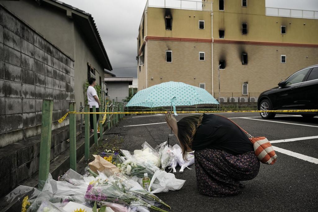 2019年7月19日，一名婦女在京都動畫縱火案臨時紀念碑前祈禱。美聯社