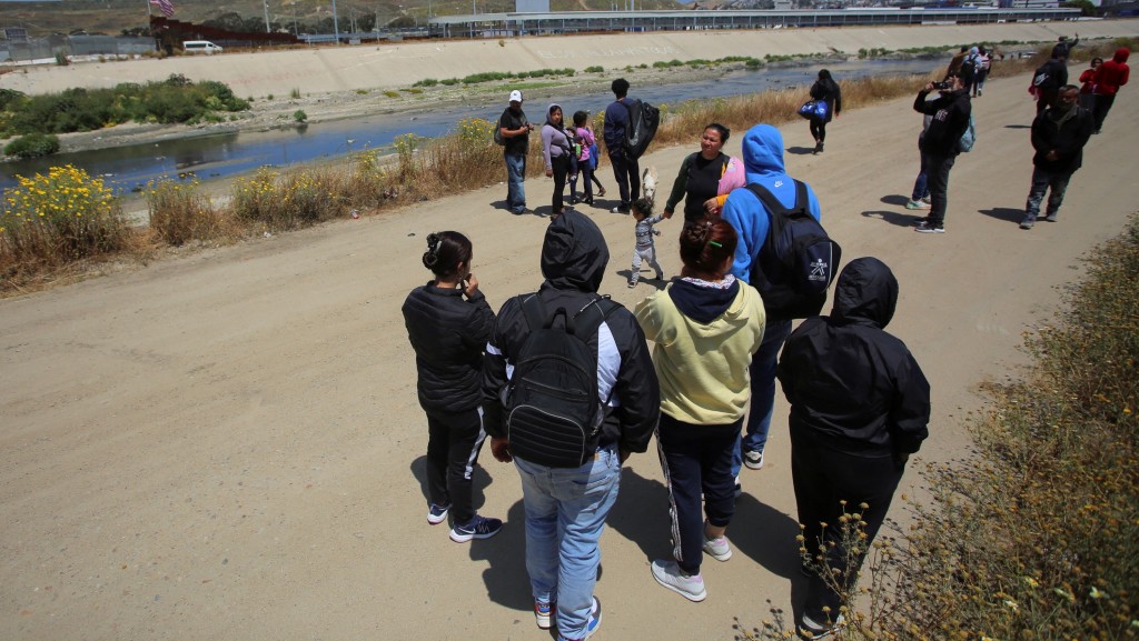 寻求庇护者在美墨边境围墙附近聚集，准备越境向美国边境巡逻队自首。 路透社