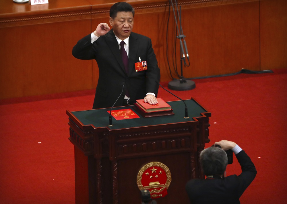 習近平舉起右手握拳宣讀誓詞,之後向人大代表鞠躬致意。美聯社