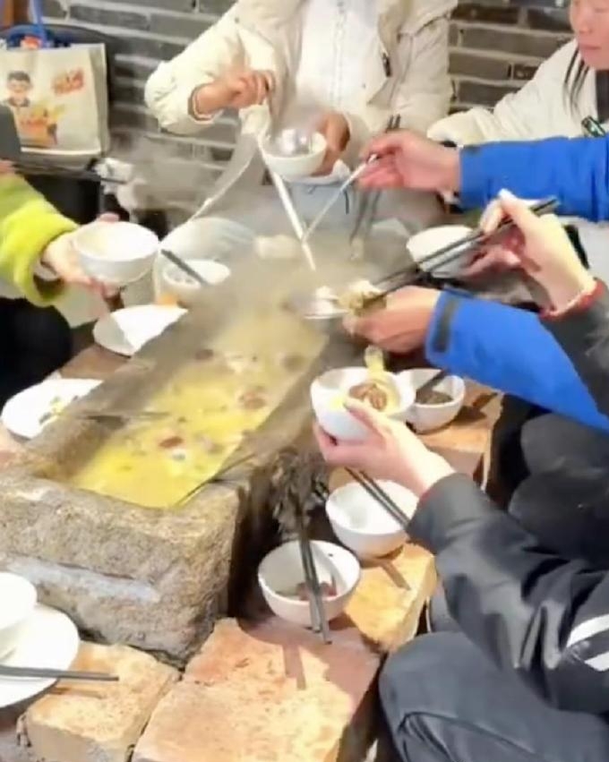 几位客人围桌“打边炉”,锅具竟是一个长约一米的青石槽。 几位客人围桌“打边炉”,锅具竟是一个长约一米的青石槽。