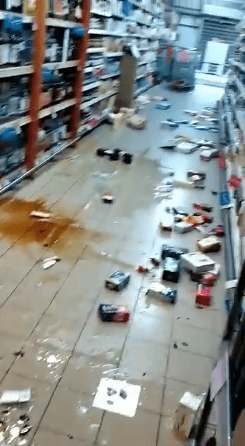 有超市貨架大量的貨物跌落地上。網圖